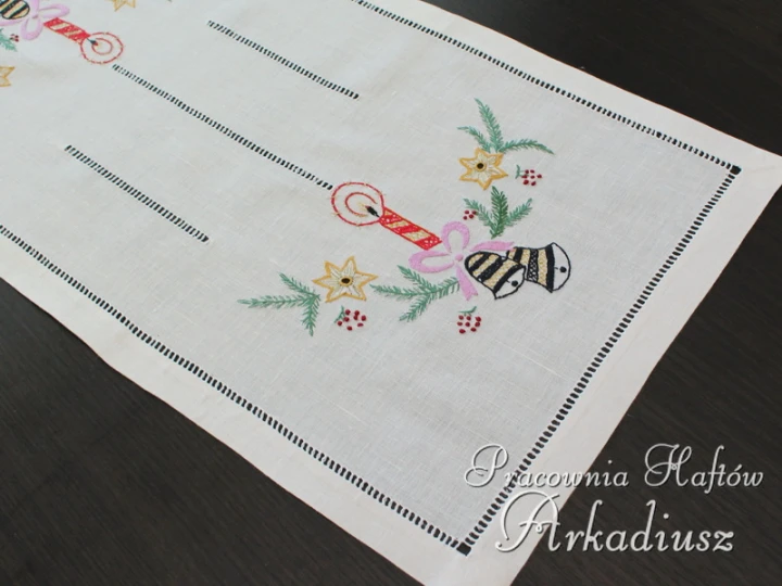 Kolorowy motyw haftu ręcznego na białym lnianym bieżniku świątecznym o wymiarach 32x65 cm.