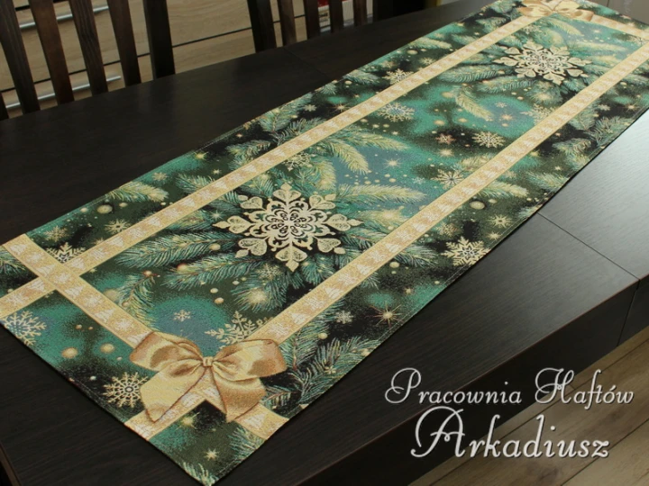 Bieżnik gobelinowy Złota kokarda 45x140 cm z motywem świątecznym na dłuższym blacie.